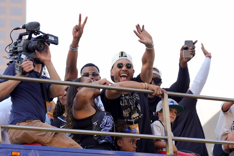 Mookie Betts de los Dodgers de Los Ángeles saluda a la afición mientras avanza en un autobús de dos pisos por las calles de Los Ángeles en el desfile de festejo tras ganar la Serie Mundial. (AP Foto/Jae C. Hong)