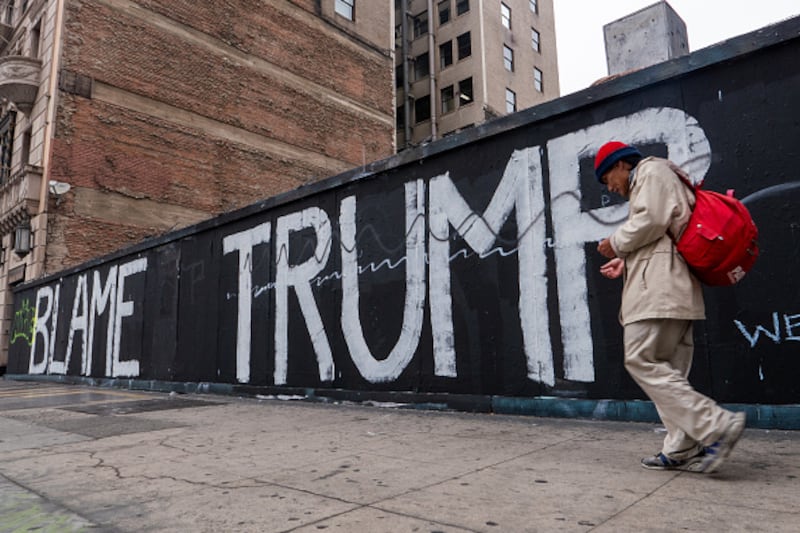 Una persona camina por el centro de Los Ángeles luego del levantamiento del toque de queda nocturno luego de que numerosos negocios fueran asaltados el lunes por la noche mientras continúan las protestas en la ciudad.