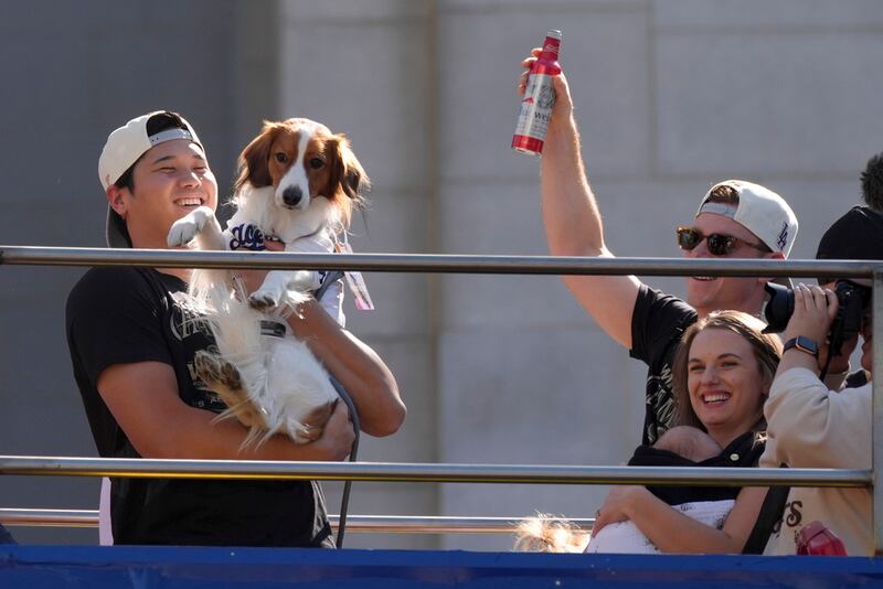 Shohei Ohtani de los Dodgers de Los Ángeles sostiene a su perro Decoy durante el desfile de campeón de la Serie Mundial en Los Ángeles. (AP Foto/Jae C. Hong)