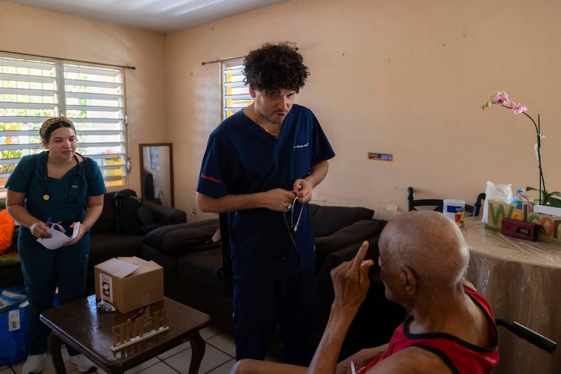 El Dr. Pedro Juan Vázquez, conocido por su nombre artístico PJ Sin Suela, atiende a un paciente en Loíza.