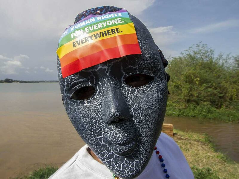 A Ugandan wearing a mask with a rainbow sticker takes part in the Gay Pride parade in Entebbe on August 8, 2015. Ugandan activists gathered for a gay pride rally, celebrating one year since the overturning of a strict anti-homosexuality law but fearing more tough legislation may be on its way. Homosexuality remains illegal in Uganda, punishable by a jail sentence. AFP PHOTO/ ISAAC KASAMANI (Photo credit should read ISAAC KASAMANI/AFP via Getty Images)