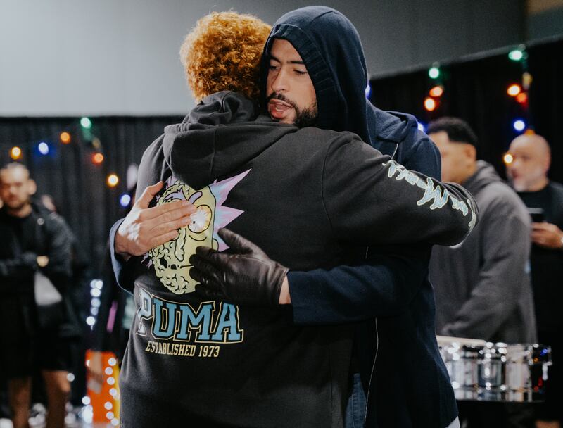 Bad Bunny abraza a niño durante evento de entrega de regalos.