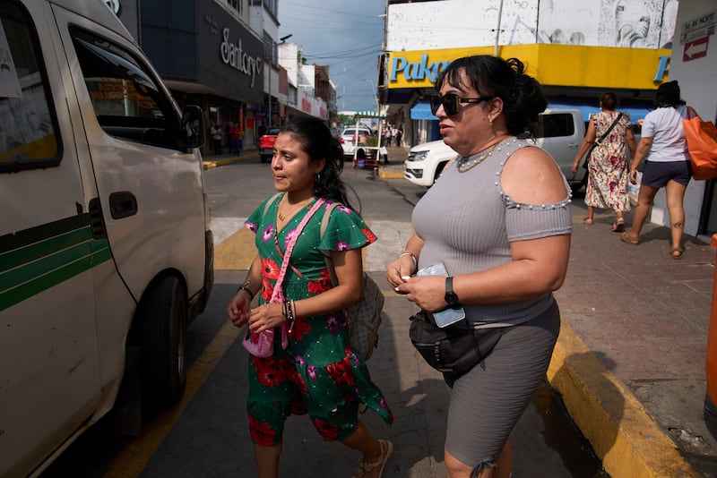 Ana Esquivel, a la derecha, que solicitó asilo en México, sube a un autobús en Tapachula, estado de Chiapas, México, el martes 11 de marzo de 2025. (AP Foto/Moises Castillo)