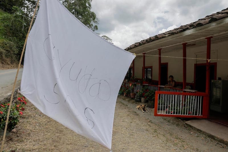 Fotografía que muestra una bandera blanca en la que se lee 'Ayuda, SOS' frente a una casa afectada por el terremoto de magnitud 7,4 del pasado lunes, en Ansermanuevo (Colombia). EFE/ Carlos Ortega