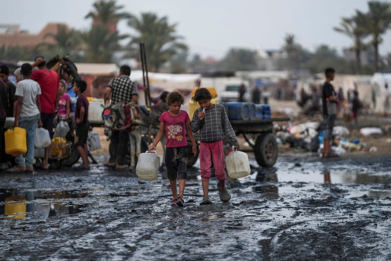 Palestinos se reúnen para llenar garrafas de agua cerca de una de las pocas plantas desalinizadoras en funcionamiento de la franja en Deir al-Balah, Franja de Gaza, el jueves 20 de junio de 2024.