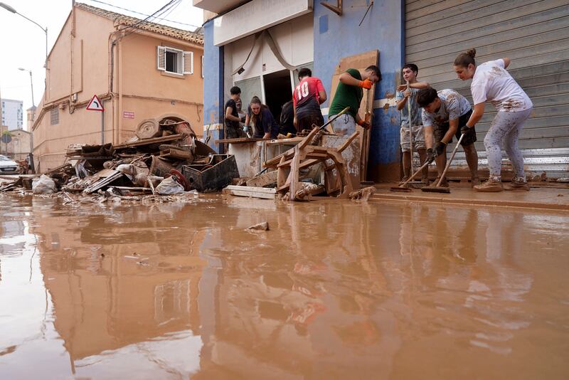 Residentes limpian sus viviendas tras las inundaciones en Valencia, España, el jueves. (AP Foto/Alberto Sáiz)