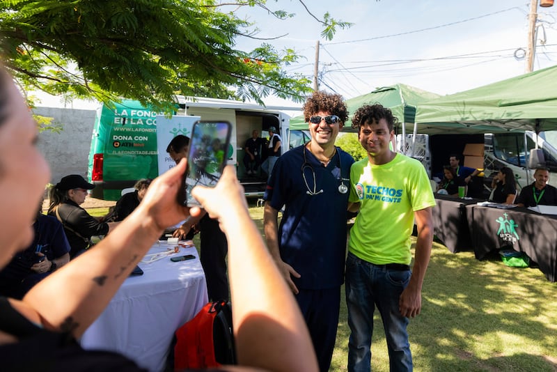 El Dr. Pedro Juan Vázquez, conocido por su nombre artístico PJ Sin Suela, posa para un retrato con un fan durante sus rondas en Loíza.