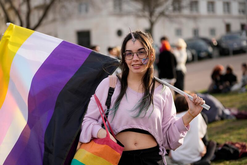 Un manifestante sostiene una bandera no binaria mientras espera el inicio de una marcha para celebrar el Día Internacional de la Visibilidad Transgénero en Lisboa.