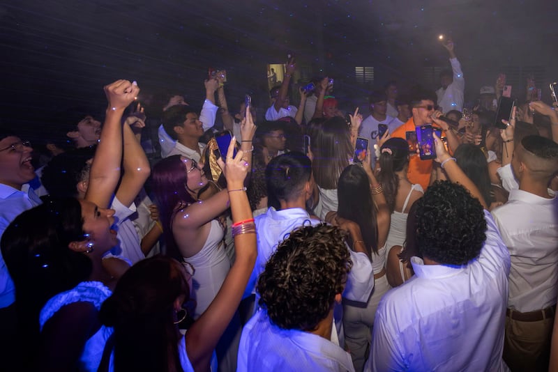 Estudiantes rodean al Dr. Pedro Juan Vázquez, conocido por su nombre artístico PJ Sin Suela, durante su presentación en un baile de graduación de una escuela superior en Camuy.
