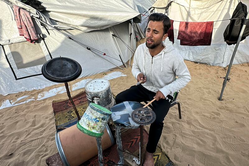 Con cajas de plástico, varas de metal, un barril y restos de una bicicleta el gazatí Hossam Qassem, de 24 años, desplazado en la zona costera de Mawasi (sur de la Franja), ha logrado construir una batería, un instrumento que le apasiona y que le sirve de terapia en medio de la desolación que persiste en el enclave palestino. EFE/