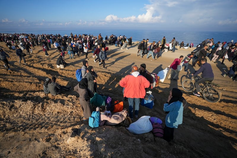 Ne'man Abu Jarad, con chaqueta roja, y su familia se toman un descanso mientras miles de palestinos desplazados regresan a sus hogares en el norte de la Franja de Gaza, luego de la decisión de Israel de permitirles regresar por primera vez desde las primeras semanas de la guerra de 15 meses con Hamas, el lunes 27 de enero de 2025. (Foto AP/Abdel Kareem Hana)