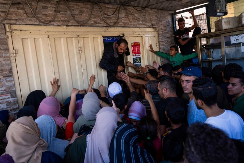 Palestinos se amontonan para comprar pan en una panadería de Jan Yunis, Franja de Gaza.