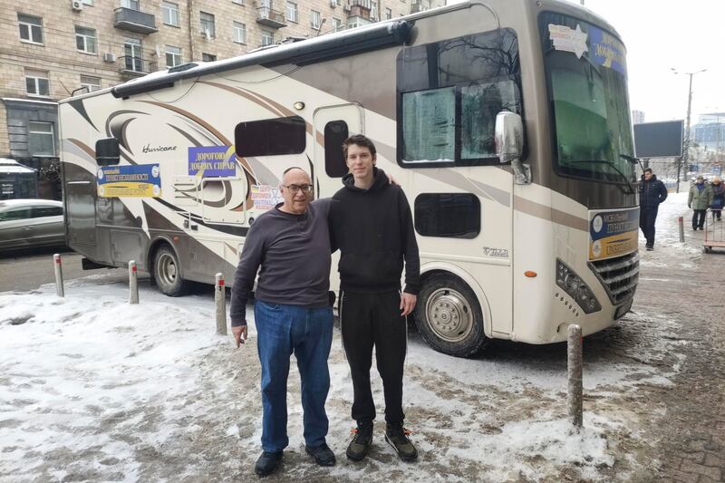 Los voluntarios de la comunidad judía de Kiev Glenn Kolleeny y Ruven Gabrovoy, este jueves, delante del camión-caravana en el que ofrecen electricidad y un espacio cálido durante los apagones y los cortes de suministro por los bombardeos rusos. EFE/ Marcel Gascón
