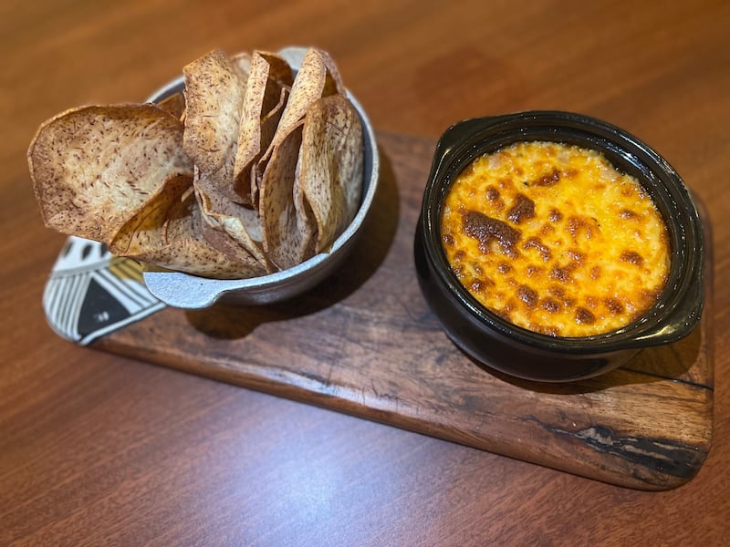 Queso fundido con longaniza del país acompañado con chips de malanga hechos en casa todos los días.