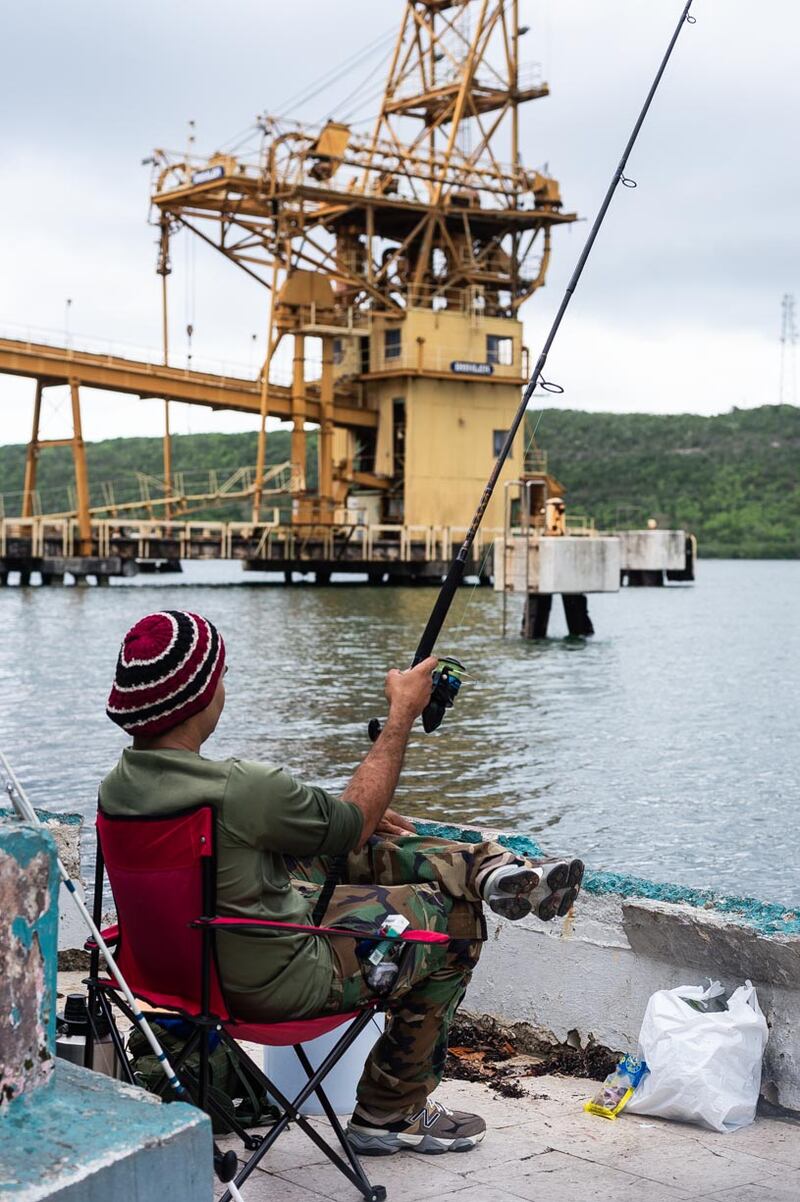 Un pescador de orilla practica la pesca recreativa en la Bahía de Guánica. Al fondo, parte de las estructuras del muelle que administra la Autoridad de Puertos.
Foto por José Miguel Morales | Centro de Periodismo Investigativo