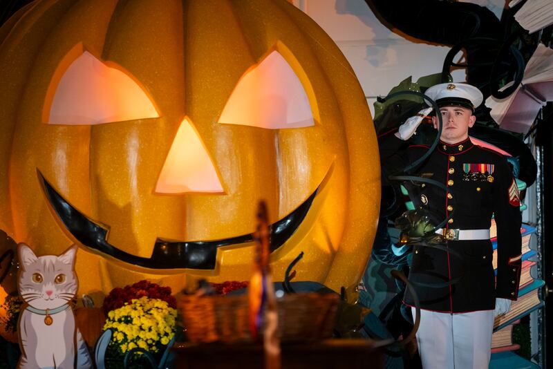 A member of the Marine Corps honor guard salutes as President Joe Biden and first lady Jill Biden leave after hosting local area students, military-connected children, and neighborhood families for trick-or-treating, ahead of Halloween on Thursday, at the South Lawn of the White House in Washington Wednesday, Oct. 30, 2024. (AP Photo/Ben Curtis)