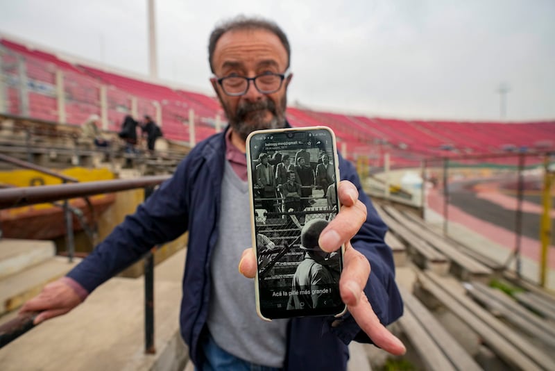 ARCHIVO - Sergio Muñoz muestra una foto de cuando estuvo detenido en el Estadio Nacional, el cual utilizado como un centro de detención y torturas en los primeros días de la dictadura militar.