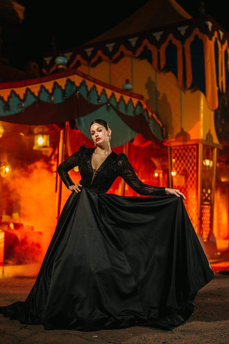 El nuevo vestido de novia de Disney's Jafar se muestra en el escenario de Agrabah Bazaar en Magic Kingdom Park en Walt Disney World en Lake Buena Vista, Florida. Es uno de los cuatro nuevos vestidos inspirados en los villanos de Disney y presentados como parte del cuento de hadas de Disney de 2024. Colección de bodas de Allure Bridals. Inspirado en el villano de Aladdin de Disney, el vestido ofrece un escote pronunciado acentuado por un cuello de satén. Está disponible en marfil o negro y presenta mangas largas ligeramente abultadas con puños abotonados.