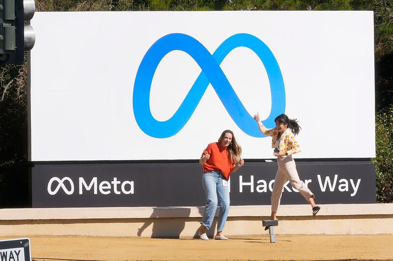 Empleados de Facebook se toman una foto con el nuevo nombre y log de la compañia afuera de su sede en menlo Park, California, el 28 de octubre de 2021. (AP Foto/Tony Avelar, Archivo)