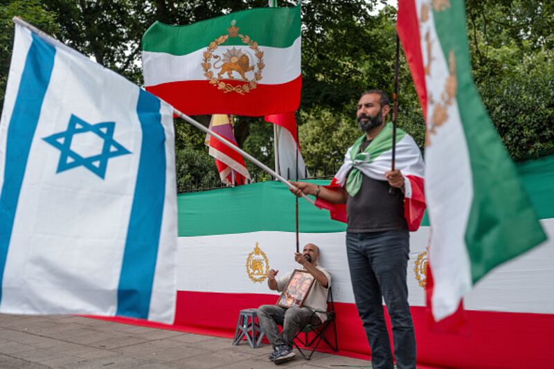 Manifestantes ondean las banderas de Israel y de Pahlavi Irán mientras se manifiestan contra el régimen iraní cerca de la embajada iraní el 24 de junio de 2025 en Londres, Inglaterra.
