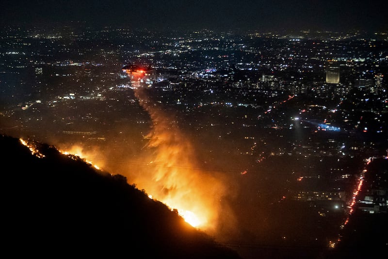 Agua es rociada desde un helicóptero sobre el incendio Sunset Fire en la sección Hollywood Hills de Los Ángeles.
(Foto AP/Ethan Swope)