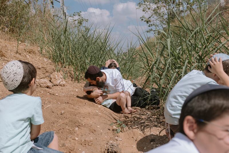 Israelíes se refugian al sonar una sirena que advierte que llegan cohetes disparados desde Gaza, en Rehovot, Israel.