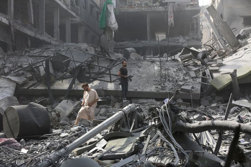 Palestinos inspeccionan los daños de edificios destruidos tras los ataques aéreos israelíes sobre Ciudad de Gaza, el lunes.