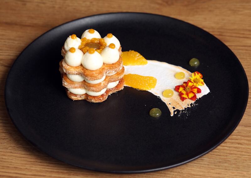 Crujiente hojaldre con mandarina confitada, ganache de vainilla, gelatina de piña, caviar de mango y merengue de ‘butterscotch’.