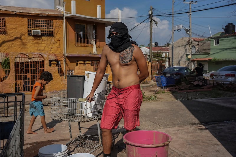 Un hombre espera su turno para recoger agua tras el azote del huracán Otis.