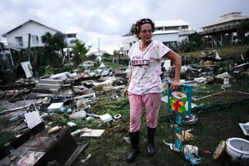 Jewell Baggett, de pie junto a una decoración navideña que recuperó de entre los restos de la casa de su madre, mientras busca otras pertenencias en la casa rodante que su abuelo adquirió en 1973 y en la que se hicieron varias ampliaciones a lo largo de las décadas, en Horseshoe Beach, Florida.