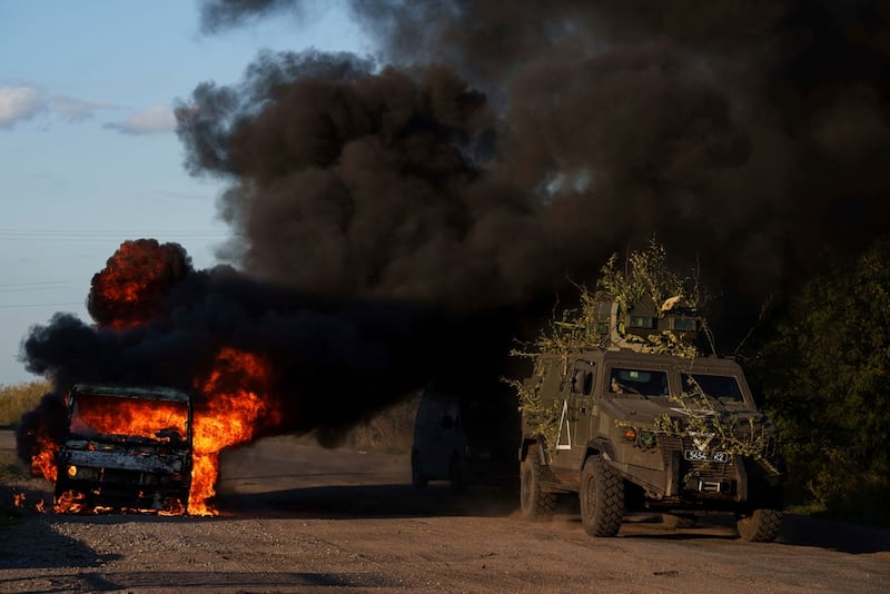 Un vehículo militar blindado ucraniano pasa junto a un automóvil quemado cerca de la frontera entre Rusia y Ucrania, en la región de Sumy, Ucrania, el miércoles 14 de agosto de 2024. (Foto AP/Evgeniy Maloletka)