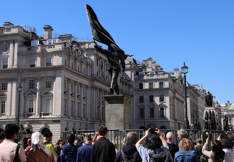 Varias personas observan una obra de arte de Banksy: una estatua de un hombre ondeando una bandera sobre un pedestal en el centro de Londres, Gran Bretaña, el 30 de abril de 2026. (Reino Unido, Londres) EFE/EPA/ANDY RAIN