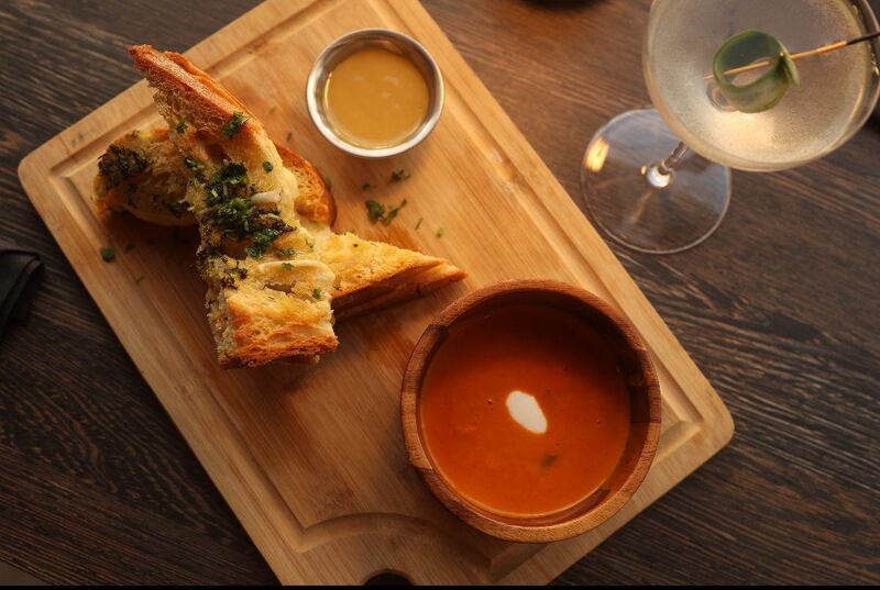 Sándwich de queso fundido —inspirado en un grilled cheese clásico— combina gouda, muenster y havarti con aceite de trufa y mostaza de miel de la casa.