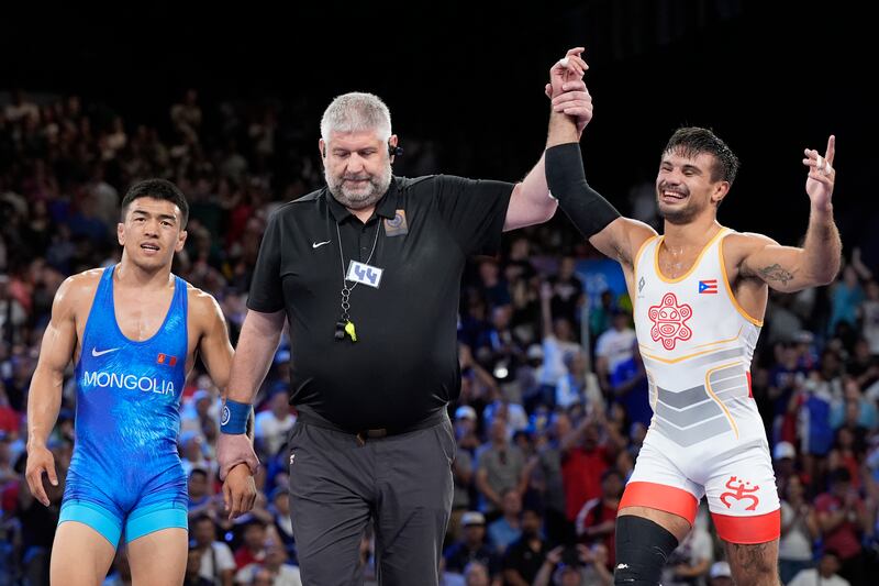 El puertorriqueño Sebastián Rivera celebra después de derrotar a Tumur Ochir Tulga de Mongolia en su combate por la medalla de bronce en la categoría libre masculina de 65 kg en la Arena Champ-de-Mars, durante los Juegos Olímpicos de Verano de 2024, el domingo 11 de agosto de 2024, en París, Francia. (Foto AP/Eugene Hoshiko)