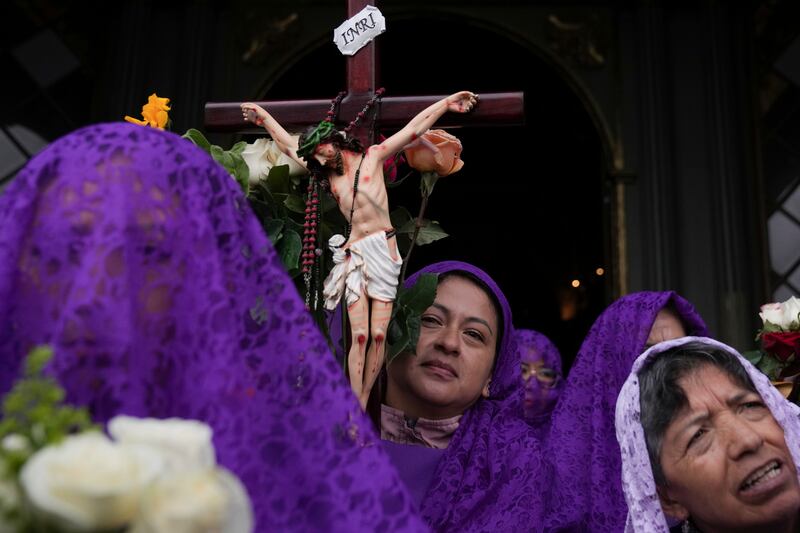 Penitentes, conocidas como Verónica, porta un Cristo crucificado durante la procesión de Jesús del Gran Poder, como parte de la celebración de la Semana Santa, en Quito, Ecuador, el 29 de marzo de 2024. La Semana Santa conmemora los últimos días de la vida de Jesús, según la Biblia, incluyendo su crucifixión el Viernes Santo y su resurrección en el Domingo de Pascua. (AP Foto/Dolores Ochoa)
