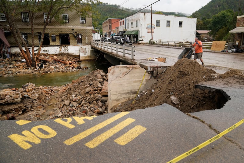 Len Frisbee arroja una carretilla de tierra mientras ayuda con la limpieza después del huracán Helene en Hot Springs, Carolina del Norte. (AP Photo/Jeff Roberson)