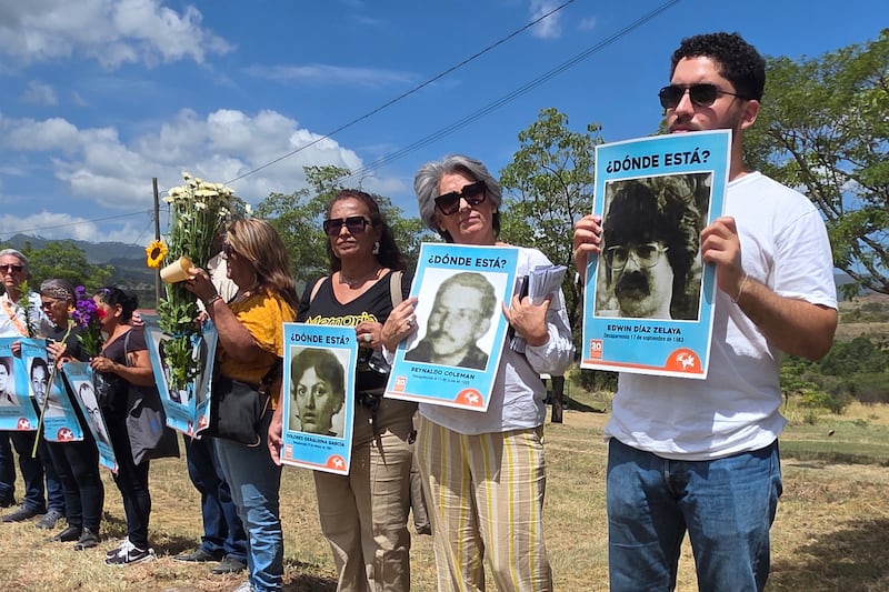 Personas sostienen retratos de sus familiares desaparecidos por motivos políticos en los años 80, este sábado durante la víspera de la conmemoración del 'Día Nacional del Detenido Desaparecido', en Amarateca al norte de Tegucigalpa (Honduras). EFE/ Germán Reyes
