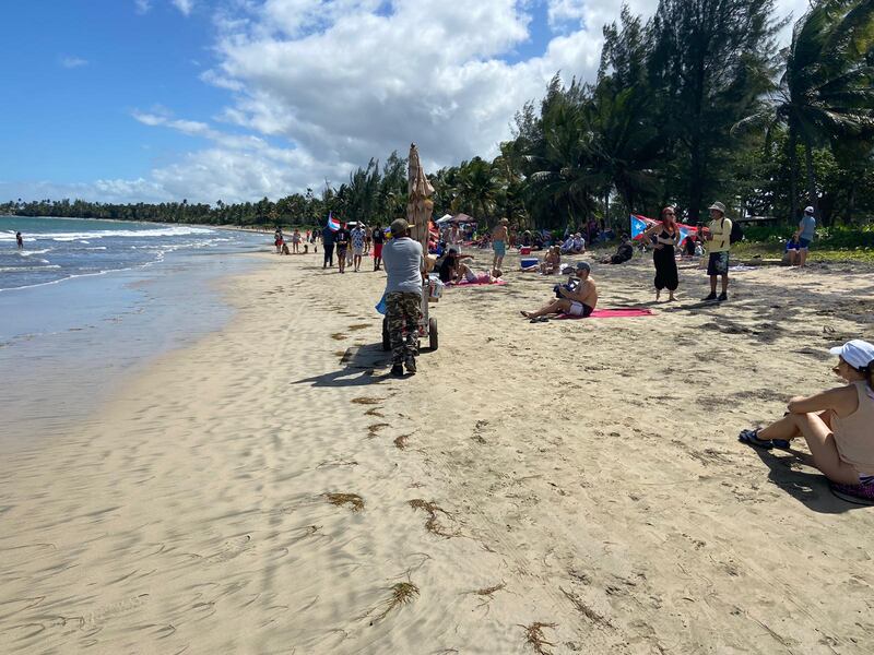 Con chanclas, botas y cargando neveras de playa, decenas de manifestantes intentaron hoy, sábado, cruzar el tramo de la orilla de Dorado Beach
