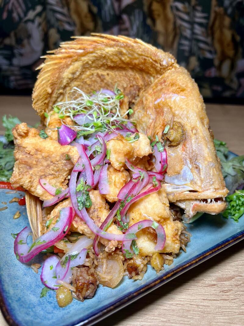 Capitán frito servido con arroz frito y ensalada de La Flaka: mixología conceptual y cocina fusión