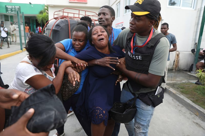 ARCHIVO - La esposa de un periodista que recibió un disparo durante un ataque armado de una pandilla en el Hospital General llora mientras una ambulancia llega con su cuerpo a otro hospital en Puerto Príncipe, Haití, el 24 de diciembre de 2024. (Foto AP/Odelyn Joseph, Archivo)