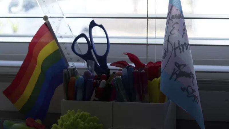 Banderas que representan los derechos de las personas transgénero y LGBTQ+ en el escritorio de Charlie Suor en su casa en Tampa, Florida