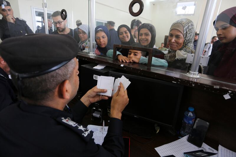 Palestinos con doble nacionalidad se registran para cruzar a Egipto desde la Franja de Gaza, en el interior del paso fronterizo de Rafah.