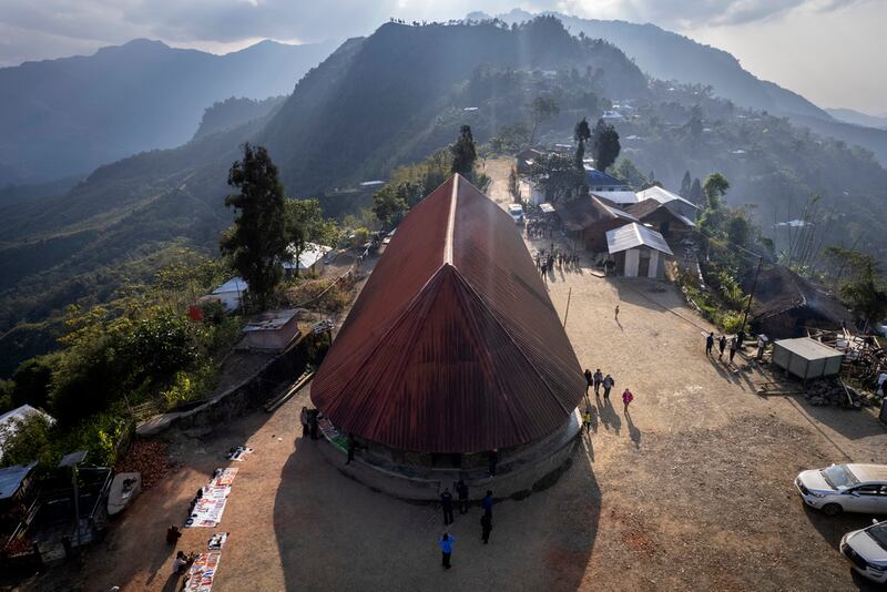 Esta toma aérea muestra una vivienda de techo rojo de chapa corrugada, donde vive el angh -el jefe tribal--, la cual yace tanto en Myanmar como en India, en el poblado Longwa, India. (AP Foto/Anupam Nath)