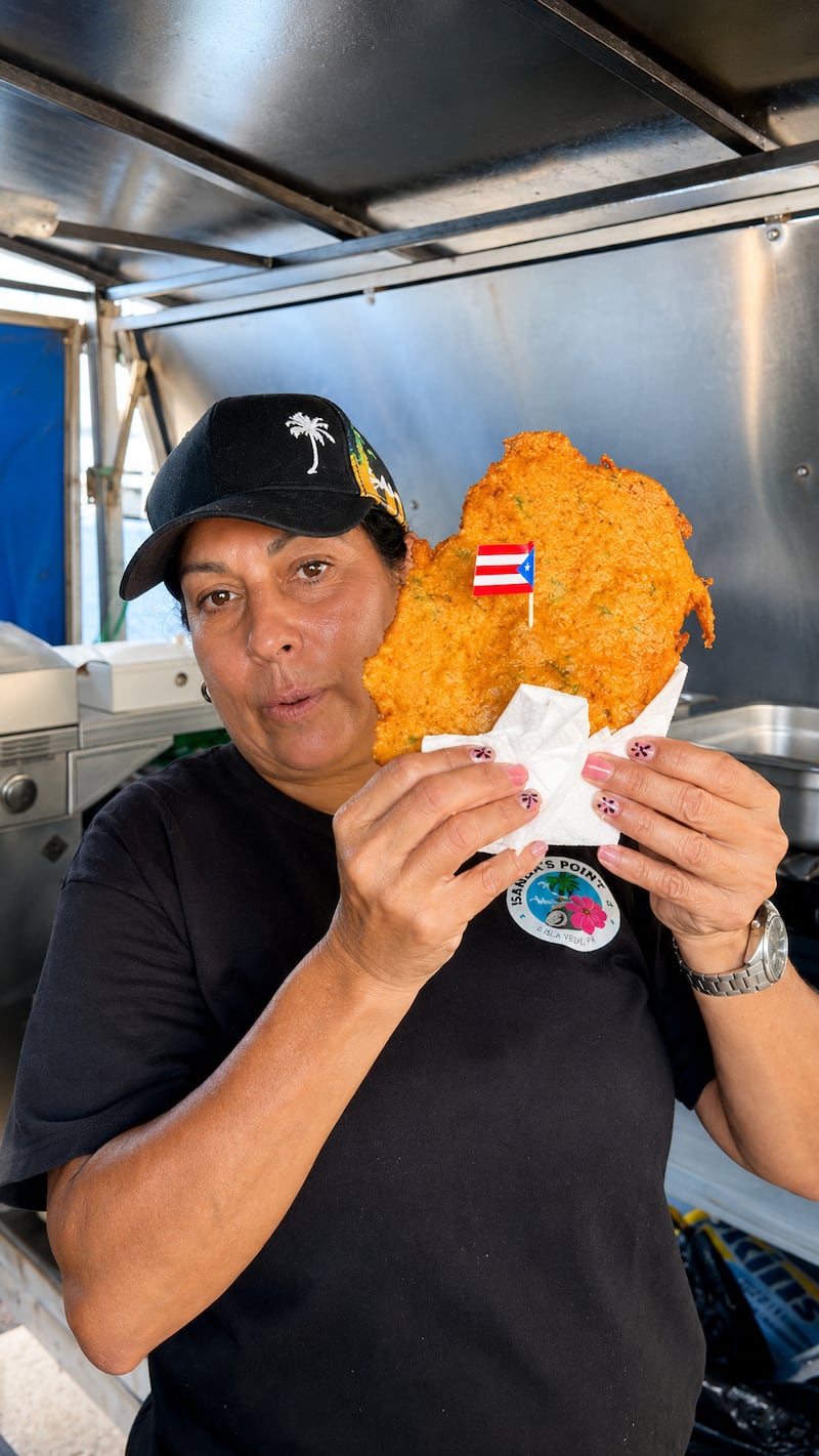 Sandra muestra uno de los favoritos: los bacalaítos, una de las frituras con mayor demanda en Sandra’s Point.