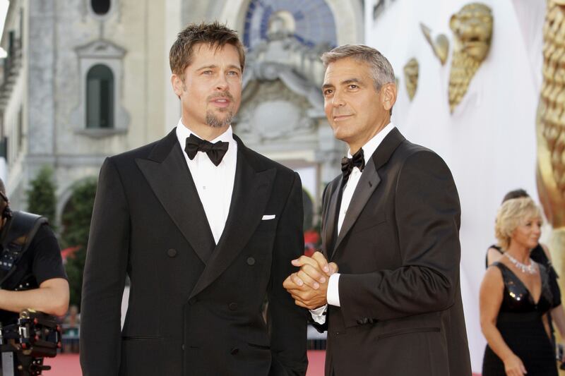 ARCHIVO - Los actores Brad Pitt, izquierda, y George Clooney en la proyección de la película 