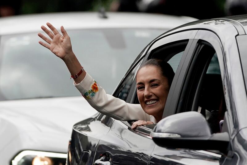 Claudia Sheinbaum saluda desde el vehículo que la llevaba al Congreso para asumir la presidencia en la Ciudad de México.  (AP Foto/Aurea Del Rosario)