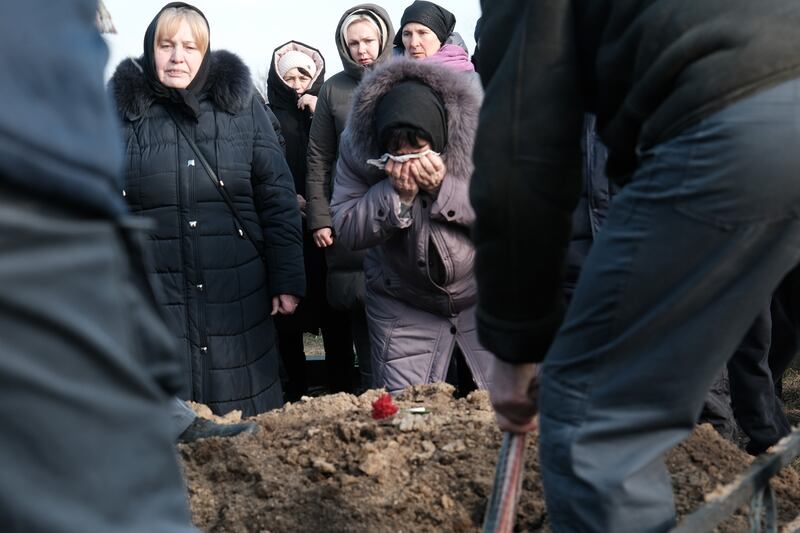 Una mujer llora mientras el ataúd del soldado ucraniano Sergiy Sochenko es colocado en la tierra el 28 de enero de 2023 en Rohoziv, Ucrania. El soldado, de 47 años, fue asesinado en batalla. Le sobreviven su esposa un hijo.