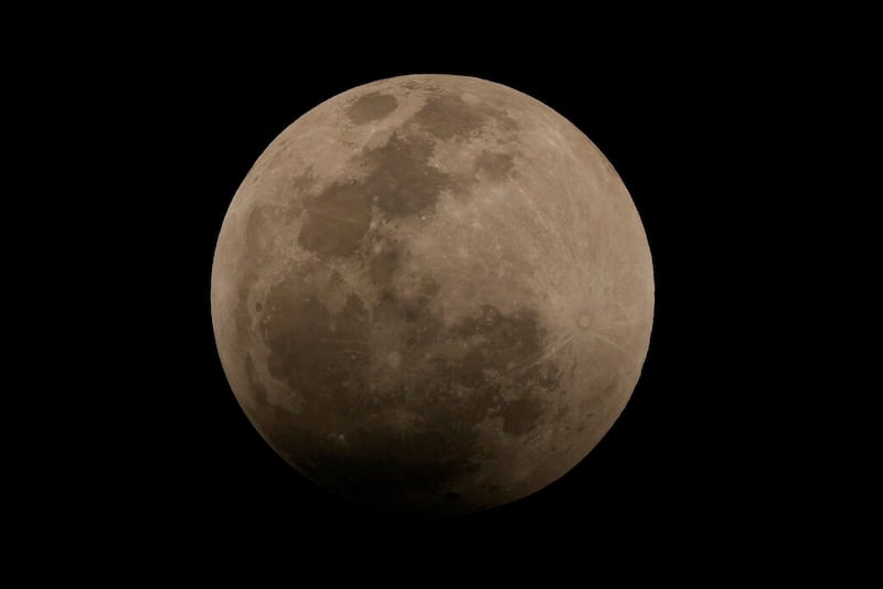The Moon is seen in the initial phase of a lunar eclipse, in Brasilia, Brazil, Sunday, May 15, 2022. (AP Photo/Eraldo Peres)