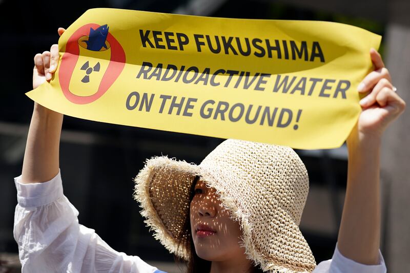 Una manifestante sostiene un cartel durante una protesta ante la sede de Tokyo Electric Power Company Holdings (TEPCO) el 16 de mayo de 2023 en Tokio