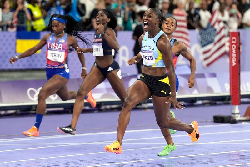 Julien Alfred, de Santa Lucía, celebra tras ganar la final femenina de los 100 metros en los Juegos Olímpicos de Verano de 2024, el sábado 3 de agosto de 2024, en Saint-Denis, Francia. (Foto AP/Matthias Schrader)